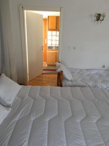 a bedroom with two beds and an open door at Apartman Struga in Struga