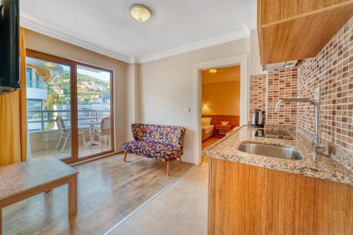 Una cocina con fregadero y una sala de estar. en Yeniacun Apart Hotel, en Alanya