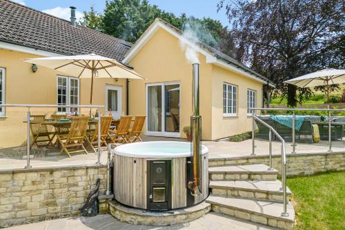 a backyard with a hot tub and a table and chairs at The Anchorage Nables Farm in Chippenham