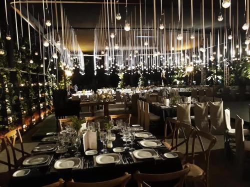 a dining room with a long table and a chandelier at Hotel Hacienda Vista Hermosa in Tequesquitengo