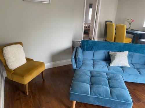 a blue couch and a chair in a living room at Fort Mews in Ballina