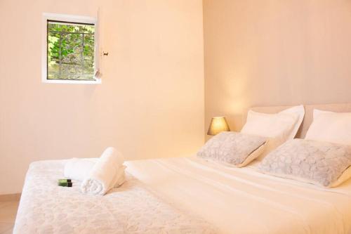 - un lit blanc avec deux oreillers et une fenêtre dans l'établissement Charming apartment city center-Grande Plage 5 min walking, à Biarritz