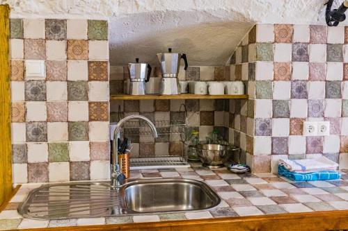 cocina con fregadero y encimera de azulejos en Cueva de la tía Flor, en Castril