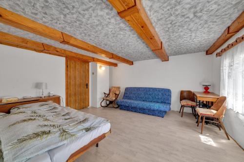 1 dormitorio con 1 cama y 1 sofá azul en Údolíčko 14 en Pürstein