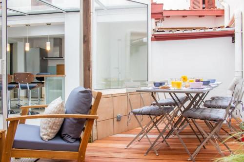 Cette chambre dispose d'un balcon avec une table et des chaises. dans l'établissement Charming apartment city center-Grande Plage 5 min walking, à Biarritz