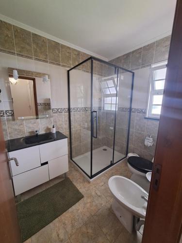 a bathroom with a shower and a sink and a toilet at Vila Flor in Lajes das Flores