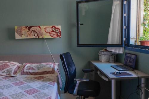 - une chambre avec un bureau et un lit avec un ordinateur portable dans l'établissement 50 meters from the Sea, Ashkelon, à Ashkelon