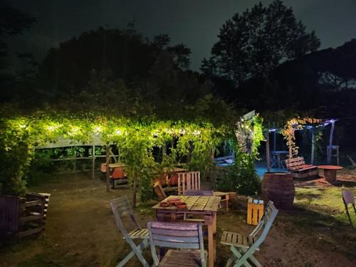 un jardín con pérgola y sillas por la noche en Brandito's, en Torre del Greco