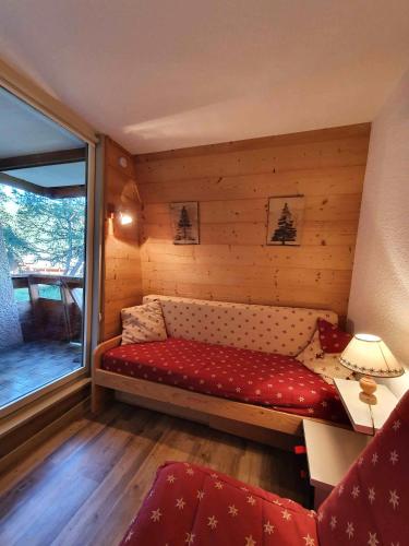 Cette petite chambre comprend un canapé et une fenêtre. dans l'établissement Studio 3 personnes, VARS LES CLAUX, Skis aux pieds, à Vars