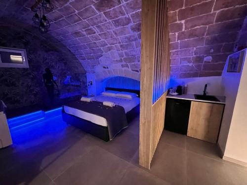 普利亞區格拉維納的住宿－Glamour suite，一间设有床铺的卧室,位于蓝色灯光的房间