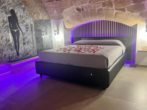 Dormitorio con cama con iluminación púrpura en Glamour suite, en Gravina in Puglia