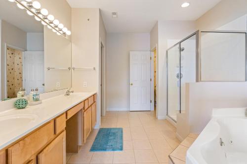 a bathroom with two sinks and a tub and a shower at Regatta Retreat in Lake Ozark