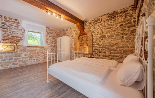 - une chambre avec un lit et un mur en briques dans l'établissement 3 Bedroom Stunning Home In Gornje Rastane, à Donje Raštane