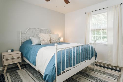 ein weißes Schlafzimmer mit einem Bett und einem Fenster in der Unterkunft Tranquil Luxury: Modern Comfort! in Lynchburg