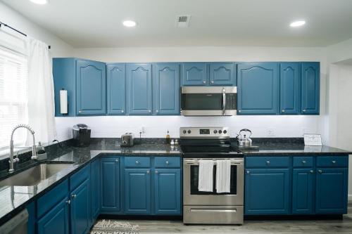 a kitchen with blue cabinets and a sink at Tranquil Luxury: Modern Comfort! in Lynchburg