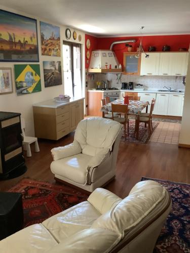 a living room with a white couch and a kitchen at EDYSHOME in Peschiera del Garda