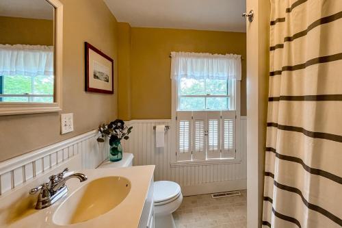 La salle de bains est pourvue d'un lavabo, de toilettes et d'une fenêtre. dans l'établissement Camden 1865, à Camden