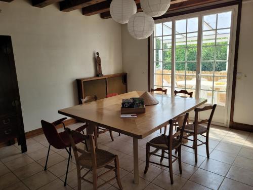 une salle à manger avec une table et des chaises en bois dans l'établissement Casateja Houlgate, à Houlgate