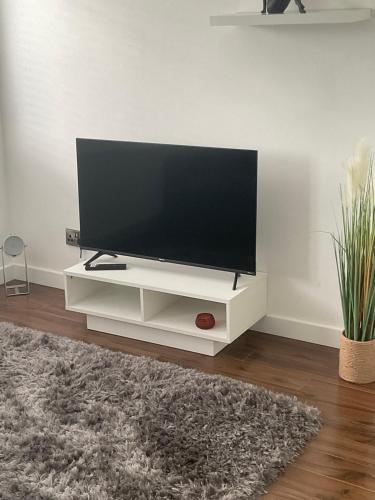 a flat screen tv sitting on a white entertainment center at Self contained guest Flat in Wick
