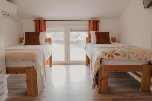 two beds in a room with a window at HomyHouse in Sibiu