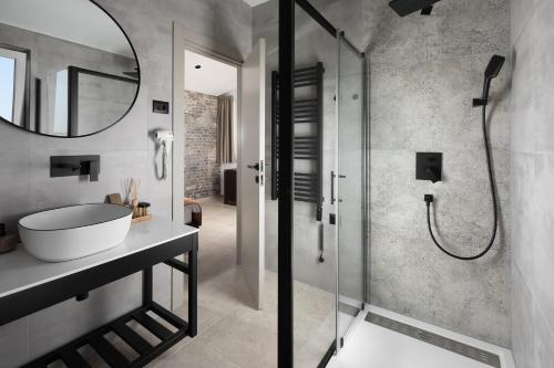 a bathroom with a shower and a sink and a mirror at Arena Prestige Rooms in Pula