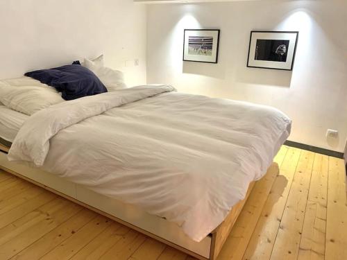 une chambre avec un grand lit avec des draps blancs dans l'établissement Charming apartment in the Chartrons district, à Bordeaux