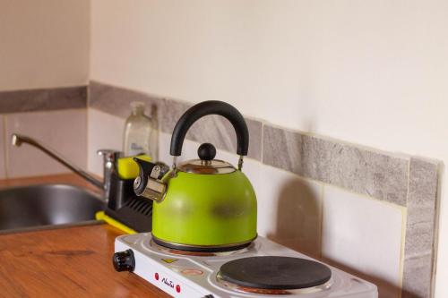 a green tea kettle sitting on top of a stove at Monoambiente Golondrina in Capilla del Monte