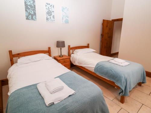 two beds in a room with towels on them at Mistal Cottage in Husthwaite