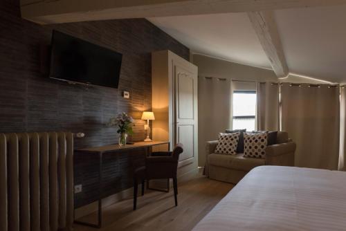 a hotel room with a bed and a desk and a couch at Art'Hotel & SPA Le Potin Gourmand in Cluny