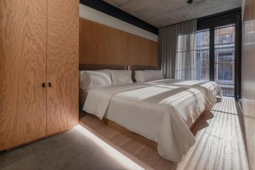 a bedroom with a large bed and a large window at Volga in Mexico City