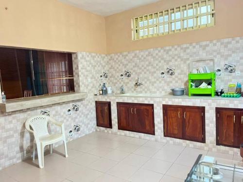 cocina con mesa y silla en una habitación en Spacieuse maison à Calavi - Comme chez vous, en Abomey-Calavi