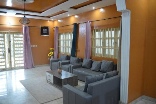 ein Wohnzimmer mit Sofas und einem Tisch in der Unterkunft Spacieuse maison à Calavi - Comme chez vous in Abomey-Calavi