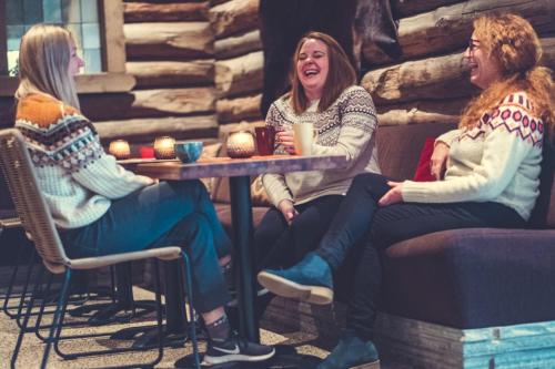 a group of three women sitting at a table at Spidsbergseter Resort Rondane in Venabygd
