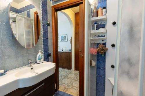 ein Bad mit einem Waschbecken und einem Spiegel in der Unterkunft casa vacanza barbera - In Riva al Mare in Trappeto
