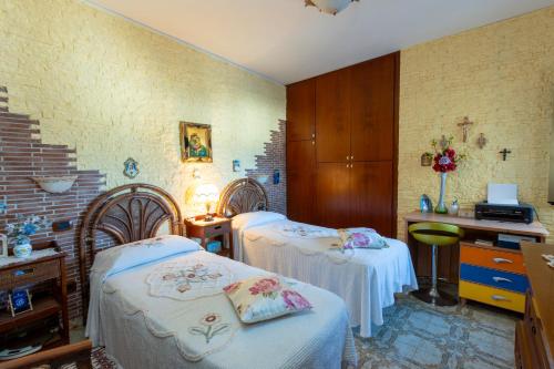 Zimmer mit 2 Betten, einem Schreibtisch und einem Schreibtisch in der Unterkunft casa vacanza barbera - In Riva al Mare in Trappeto