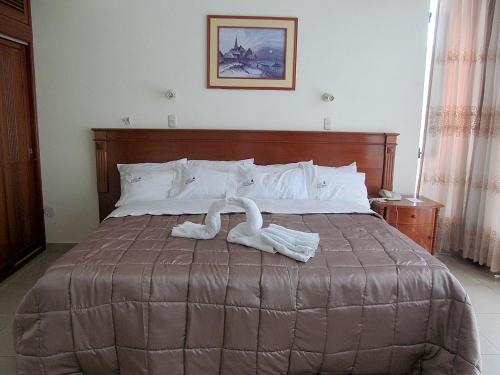 ein Schlafzimmer mit einem Bett mit zwei weißen Handtüchern darauf in der Unterkunft RIZZO HOTEL in Chiclayo