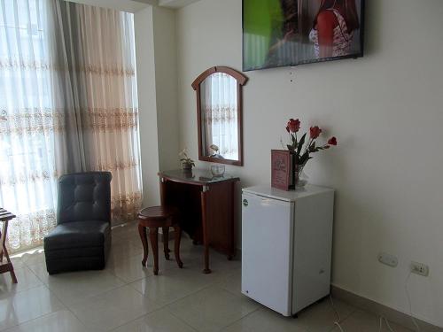 Habitación con silla, mesa y espejo en RIZZO HOTEL, en Chiclayo