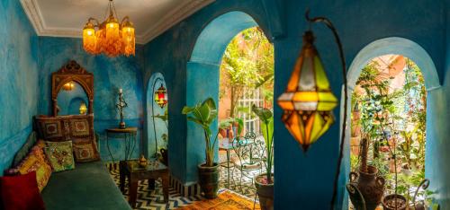 Elle comprend un salon doté de murs bleus et d'un lustre. dans l'établissement Riad Persephone, à Marrakech