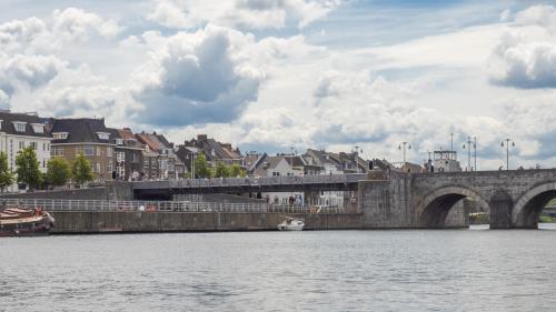 eine Brücke über einen Fluss mit einem Boot im Wasser in der Unterkunft Nautica Jansen in Maastricht