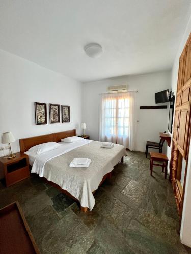 ein Schlafzimmer mit einem großen Bett und einem Fenster in der Unterkunft Antheia in Folegandros Chora