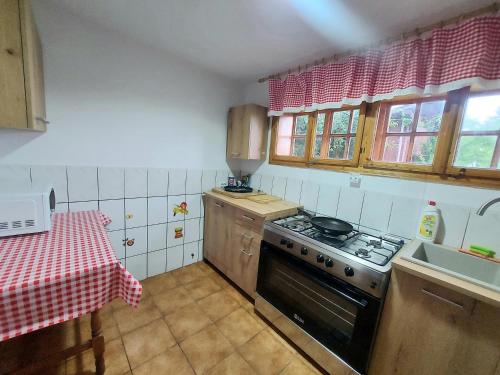 a small kitchen with a stove and a table at PENSIUNEA BOCA VORONET in Voronet