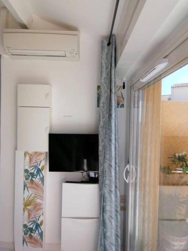 Cette chambre dispose d'une télévision à écran plat et d'une fenêtre. dans l'établissement La petite OLLY, à Mèze