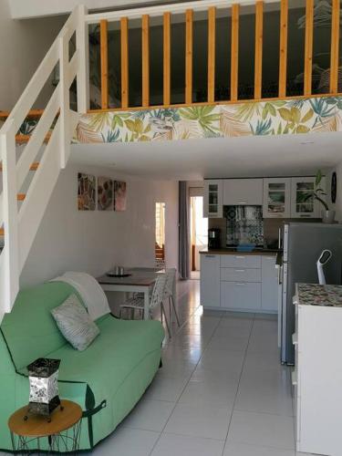 un salon avec un canapé vert et une cuisine dans l'établissement La petite OLLY, à Mèze