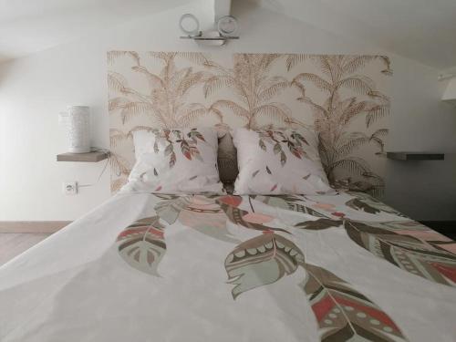 - un lit avec des draps et des oreillers blancs dans l'établissement La petite OLLY, à Mèze