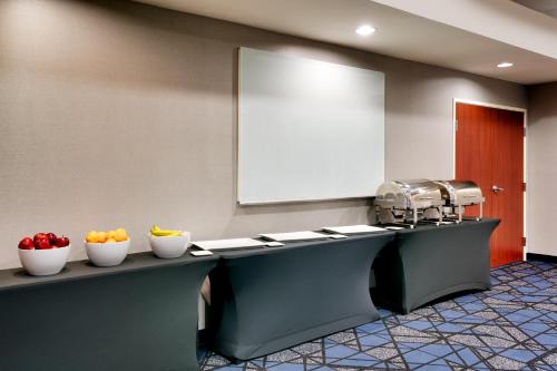 a waiting room with bowls of fruit on a counter at Courtyard by Marriott Houston NASA Clear Lake in Nassau Bay