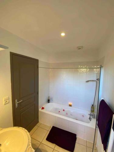 une salle de bain avec une baignoire et un lavabo dans l'établissement Splendide villa avec piscine, à Messanges