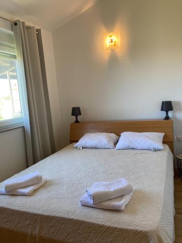 a bedroom with two towels on a bed with a window at Apartment Anabella in Fažana