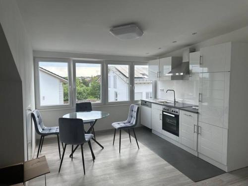 a kitchen with a table and chairs in a room at Eine wundervolle Wohnung! in Forstinning