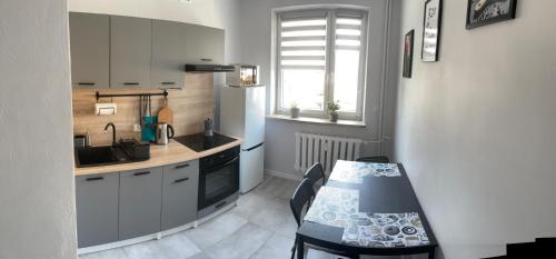 a kitchen with a table and a sink and a stove at Apartament Reszel in Reszel