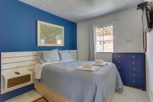 a blue bedroom with a bed with towels on it at Apart Carolina in Florianópolis
